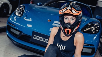 Mujer con casco posando para la foto al lado de un Porsche